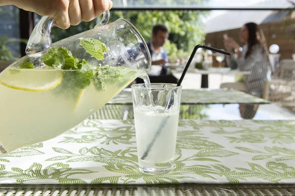 Limonata limon, nane ve buz. Cam içine dökme limonata genç adam.