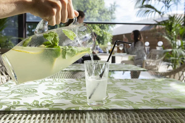 Limonata limon, nane ve buz. Cam içine dökme limonata genç adam.