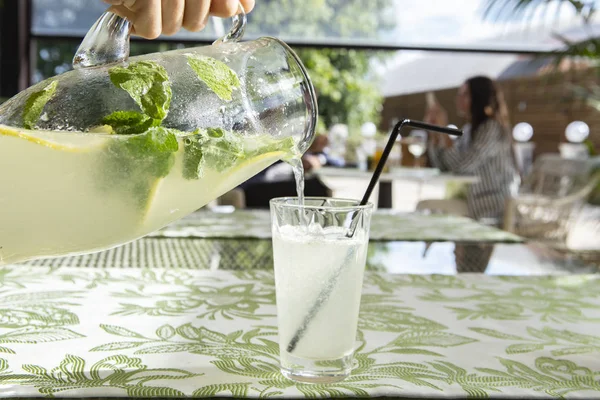 Limonata limon, nane ve buz. Cam içine dökme limonata genç adam.