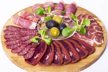 Lezzetli salamlı yemek tepsisi, dilimlenmiş jambon, sosis ve zeytin parçaları. Et tabağı.