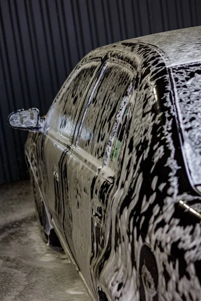 Araba yıkamada köpükle kaplanmış siyah araba.