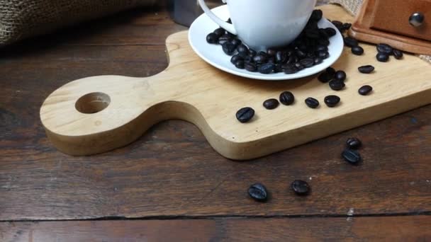木製の背景映像にコーヒー豆とコーヒー カップ — ストック動画