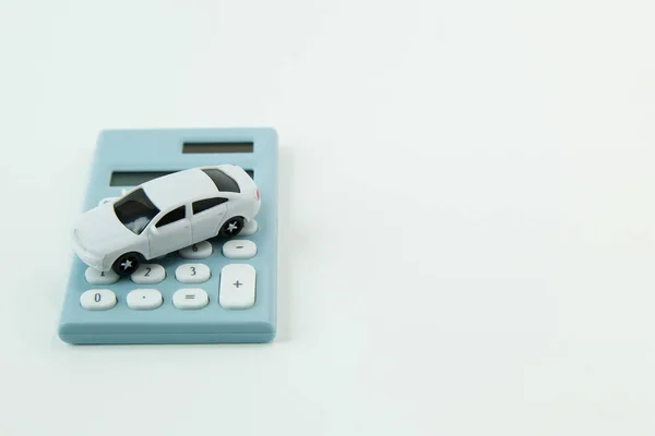 白い車のおもちゃと青い計算機ホワイト バック グラウンド — ストック写真
