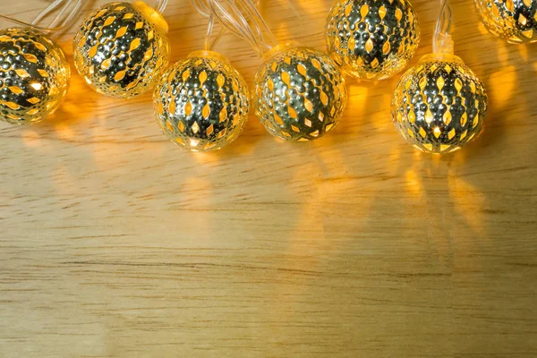 ゴールド クリスマス ライト ボールを木製のテーブルの装飾 — ストック写真