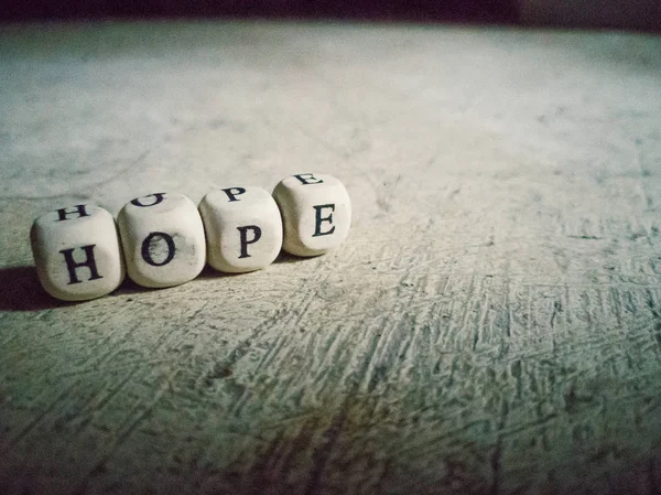 The hope word on wood brick  dirty floor close up image .
