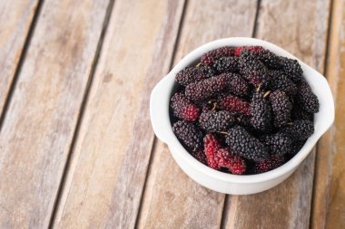  dut meyve ahşap masa üzerinde beyaz kase.