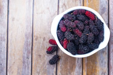  dut meyve ahşap masa üzerinde beyaz kase.