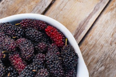  dut meyve ahşap masa üzerinde beyaz kase.