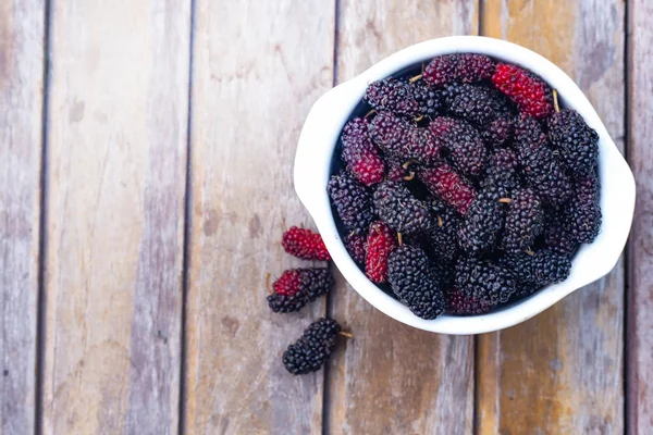  dut meyve ahşap masa üzerinde beyaz kase.