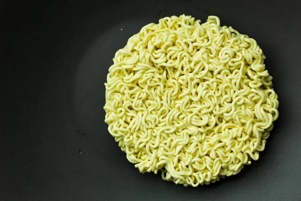 El fideos instantáneos en la placa de cerámica negro de cerca . —  Fotos de Stock