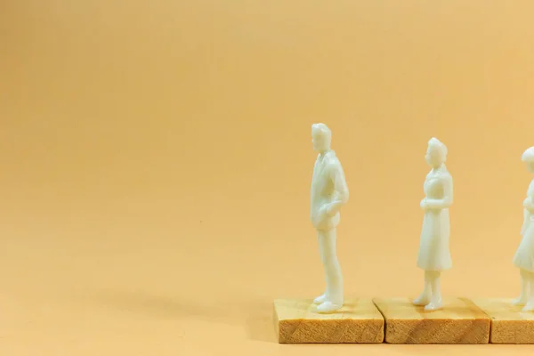 Witte figuur miniatuur op oranje pastel voor zakelijke inhoud. — Stockfoto