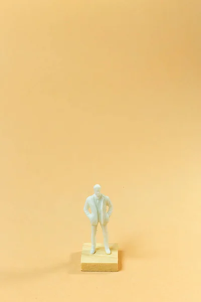 Figura blanca en miniatura sobre pastel naranja para contenido empresarial . — Foto de Stock