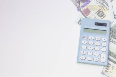 mavi hesap makinesi ve beyaz arka zemin üzerinde banknotlar. 