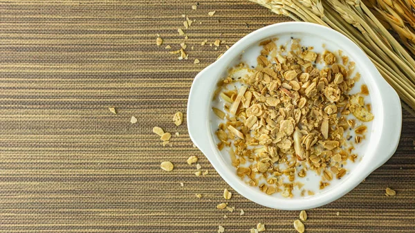 Morning food almond flakes  and milk in white bowl on wood table — Stock Photo, Image