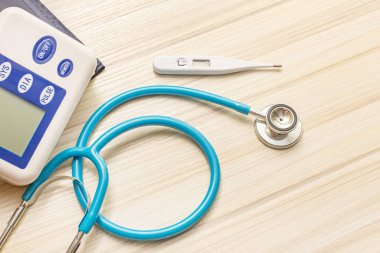 Tıbbi içerik için ahşap masa üzerinde mavi stetoskoplar.