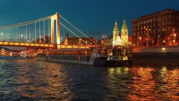 ブダペスト 2018 年頃エリザベート橋に近づいているブダペストのハンガリーの首都でドナウ川を渡る夜のボートの旅 — ストック動画