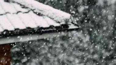 Heavy snowfall heralds the start of the winter season in the suburbs of a major city, filmed in slow motion to reveal snowflakes in glorious detail