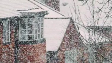 Heavy snowfall heralds the start of the winter season in the suburbs of a major city, filmed in slow motion to reveal snowflakes in glorious detail