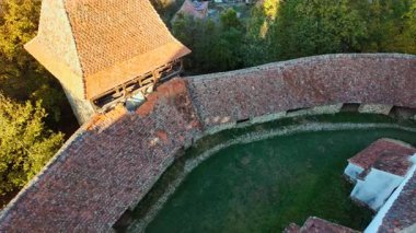 Viscri fortified church and the surrounding village and countryside, Transylvania, Romania, unites a hilltop church, enclosing walls, cobbled lanes, and open fields
