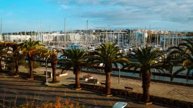 LAGOS, The Algarve, Portugal, 15 January 2025 - Panoramic view of the Lagos Marina, Lagos, The Algarve, Portugal, with boats, masts, boardwalks and waterfront cafes along calm harbor waters