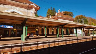 SINAIA, Romania, 12 October 2024 - Sinaia Train Station, Sinaia, Transylvania, Romania, features distinctive architecture, platform canopies, and a landmark clock, set against a mountain town backdrop