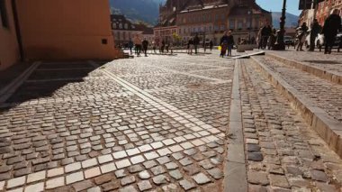 BRASOV, Romania, 14 October 2024 - Council Square Piata Sfatului, Brasov, Transylvania, Romania, with pastel facades, cobbled paving, cafes and a central fountain shaping a lively historic plaza