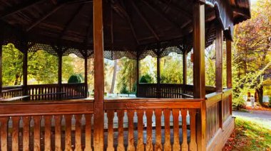 SINAIA, Romania, 12 October 2024 - Wooden gazebo in Sinaia, Transylvania, Romania, revealing stunning autumn colors, stands among bright foliage, offering clear views toward the surrounding hills