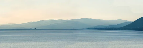 Panoramic view of ship at cold light with mountains