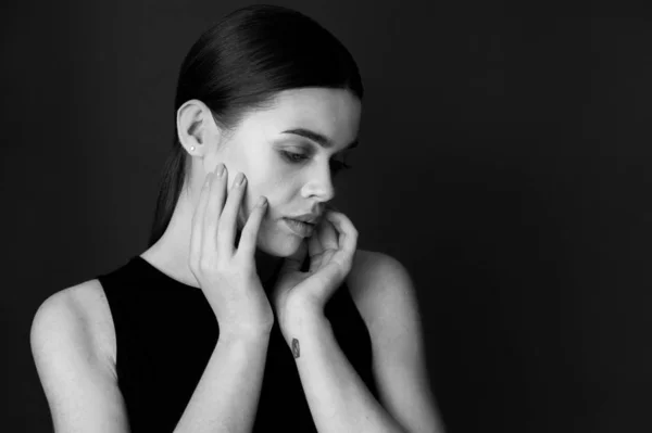 Belleza blanco y negro retrato joven modelo morena femenina en la oscuridad con las manos —  Fotos de Stock
