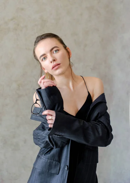Серйозна дівчина в куртці на тілі, на текстурованому фоні — стокове фото
