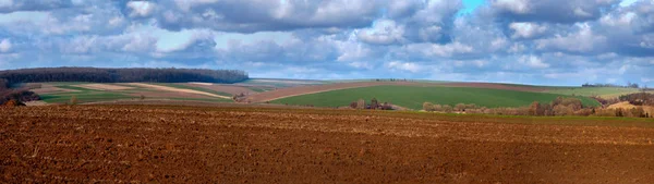 Оранжена земля з аграрним ландшафтом весни з красивим хмарним небом — стокове фото