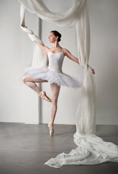 Bela bailarina está posando em estúdio com tecidos flay — Fotografia de Stock