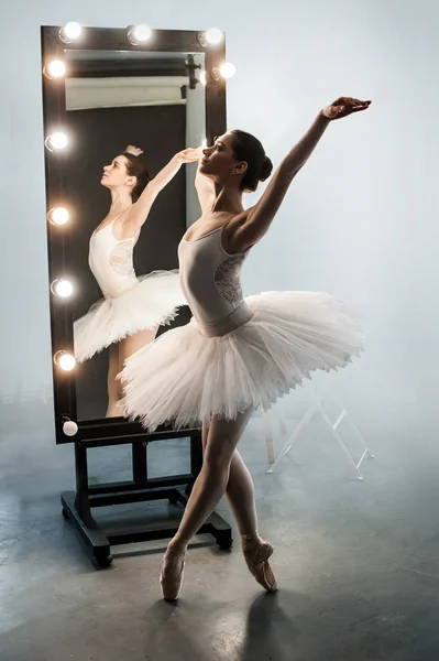 Joven hermosa bailarina está posando cerca de espejo grande —  Fotos de Stock