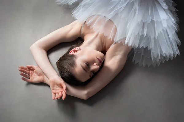 Vista superior de la bailarina en tutú estiramiento en el suelo —  Fotos de Stock