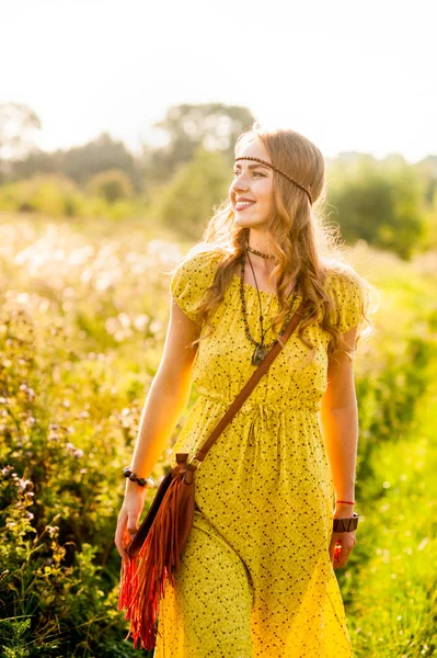 Souriant fille bohème en robe jaune avec guitare sur le terrain a — Photo