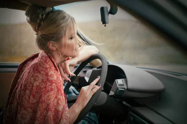 beautiful blonde woman at french style driving a retro car 80th at rainy day, relax mood