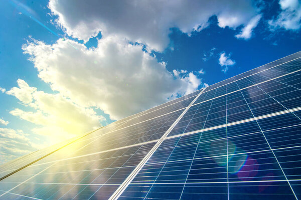 Солнечная энергетическая панель энергосистемы, вид на небо с облаками и солнечными лучами