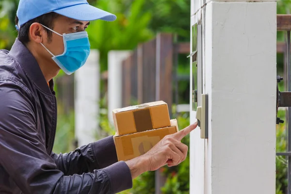 Liefermann Trägt Hygienemaske Und Blaue Mütze Schiebt Glocke Und Hält — Stockfoto