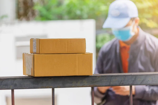 Fokus Auf Braunen Karton Mit Liefermann Tragen Hygienemaske Und Blaue — Stockfoto