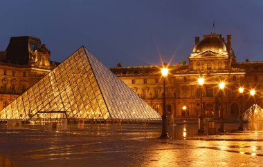 PARIS, FRANCE - 19 Eylül 2020: yağmurlu bir gecede Paris 'te Louvre Piramidi' nin yakın plan görüntüsü. 60 bin kilometrekarelik sergi alanıyla Louvre, Paris 'in en büyük müzesi..