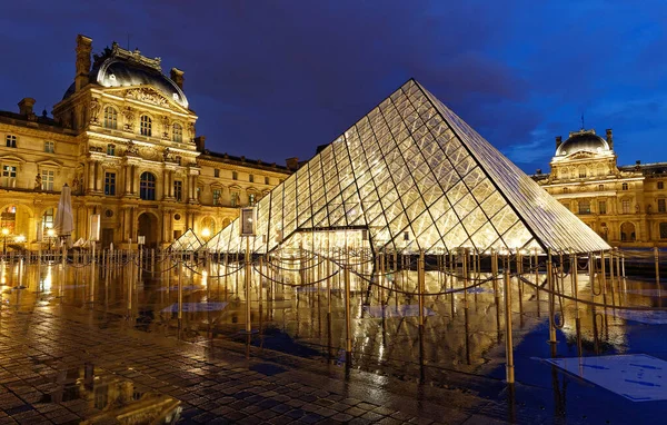 PARIS, FRANCE - 19 Eylül 2020: yağmurlu bir gecede Paris 'te Louvre Piramidi' nin yakın plan görüntüsü. 60 bin kilometrekarelik sergi alanıyla Louvre, Paris 'in en büyük müzesi..