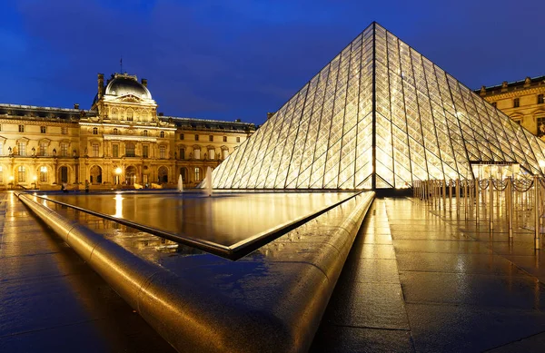 PARIS, FRANCE - 19 Eylül 2020: yağmurlu bir gecede Paris 'te Louvre Piramidi' nin yakın plan görüntüsü. 60 bin kilometrekarelik sergi alanıyla Louvre, Paris 'in en büyük müzesi..