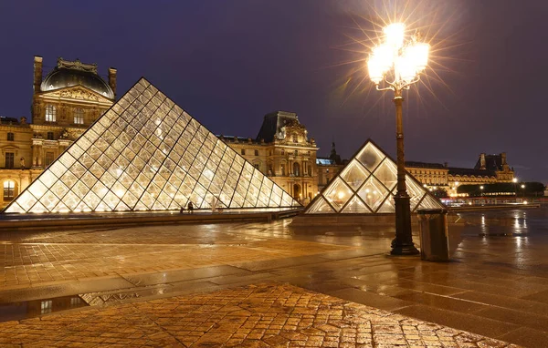 PARIS, FRANCE - 19 Eylül 2020: yağmurlu bir gecede Paris 'te Louvre Piramidi' nin yakın plan görüntüsü. 60 bin kilometrekarelik sergi alanıyla Louvre, Paris 'in en büyük müzesi..