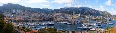 Kırmızı çatıları, katmanlı yüksek binaları ve yemyeşil tepeleri olan Monako şehrinin yüksek manzarası. Prensliğin manzaralı kentsel manzarası modern mimariyi Akdeniz cazibesiyle harmanlıyor..