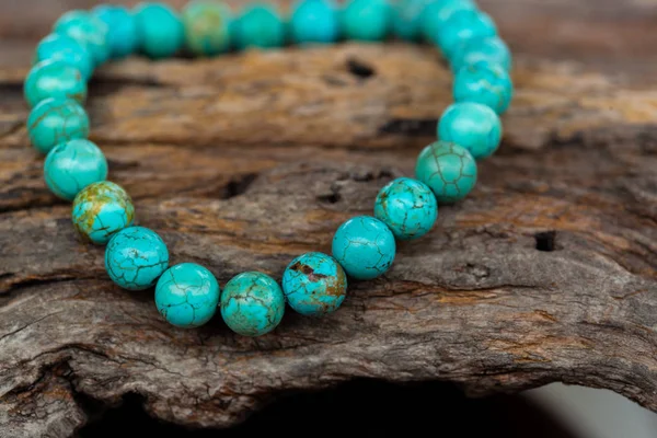 The Turquoise stone bracelet on the stump wood