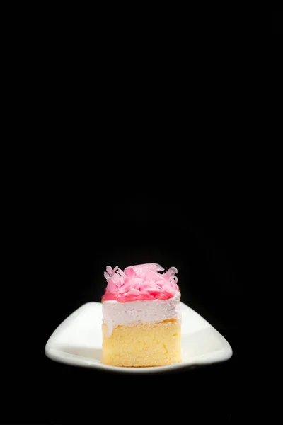 黑色背景上白色盘子上的甜蛋糕 — 图库照片