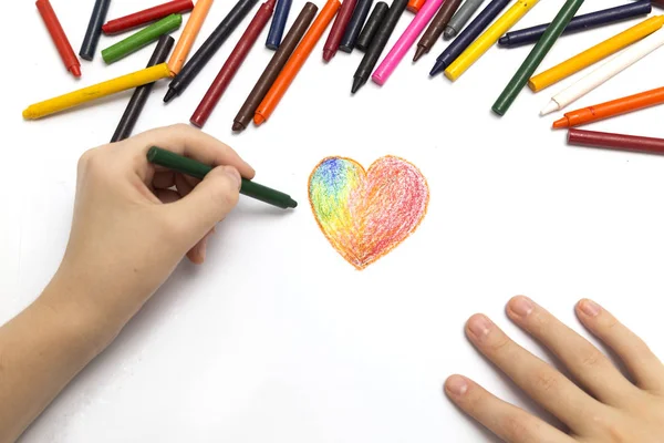Sol el renkli boya kalemleri pastel ile bir kalp şekli çizim