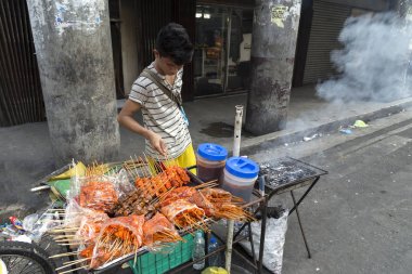 Manila, Filipinler - 16 Temmuz 2016: Sokak gıda satıcısı çocuk