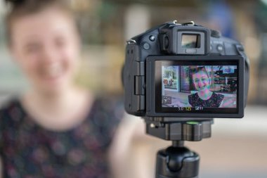 Bir beyaz genç kız kamera arkasında bir video blog (vlog) yapma