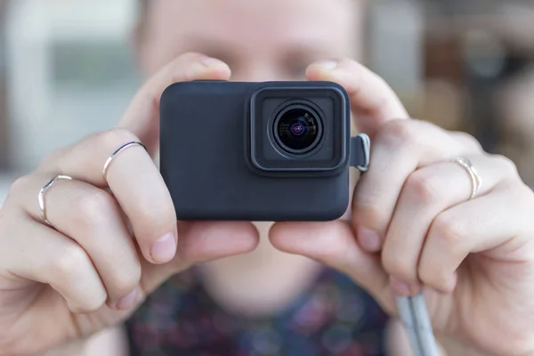 女性の手は ビデオや写真を撮る小さな黒のアクションカメラを保持してクローズアップ — ストック写真